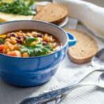 tigela de sopa com fatias de pão ao lado