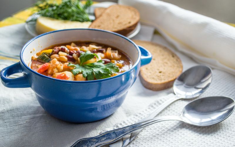 tigela de sopa com fatias de pão ao lado