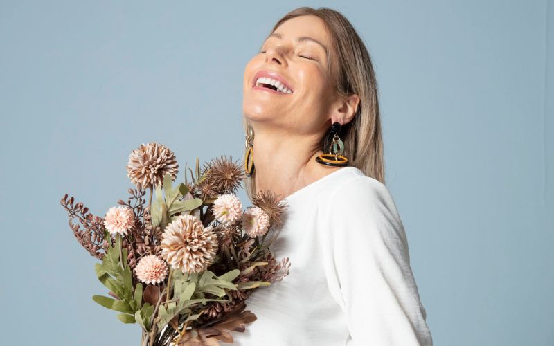 mulher feliz com um buque de flores que recebeu no dia das mulheres